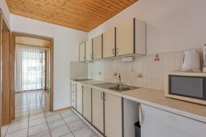 kuchnia z białymi szafkami i zlewem w obiekcie Apartments Kiki Spada w Poreču