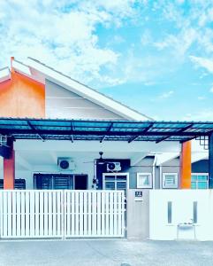 una casa con una recinzione bianca davanti di Homestay Akasia 12 a Seri Iskandar