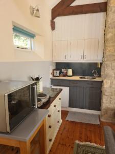 a kitchen with white cabinets and a counter top at The Old Art Studio - very large airy room sleeps up to 4 in Axminster