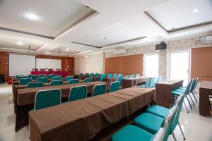 una sala de conferencias con mesas, sillas y una pantalla en RedDoorz Syariah near RS Yos Sudarso Padang en Padang