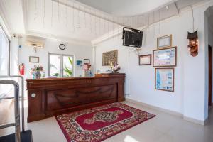 a living room with a large wooden table and a red rug at RedDoorz Syariah near RS Yos Sudarso Padang in Padang +31 photos