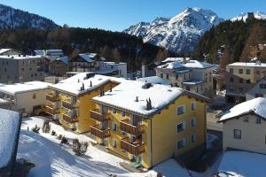 una città nella neve con una montagna sullo sfondo di Cà Val Forno - Vacanze con stile a Maloja