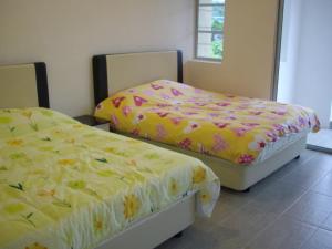 two beds sitting next to each other in a room at Greenleaf Angsana Homestay in Jerantut