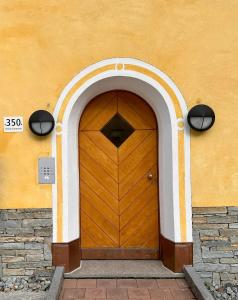 eine Holztür in einem Gebäude mit einem Torbogen in der Unterkunft Cà Val Forno - Vacanze con stile in Maloja