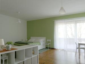 Un dormitorio con una cama con paredes verdes y una mesa. en Casetta con terrazza en Como