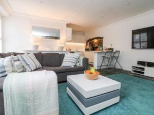 a living room with a couch and a table at Rock House in Tintagel