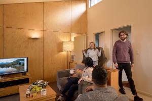 un grupo de personas de pie en una sala de estar en Cradle Mountain Wilderness Village en Cradle Mountain