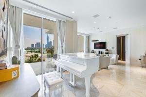 a white piano in a living room with a view of the city at Daniels 2BR Five Palm Breathtaking view in Dubai