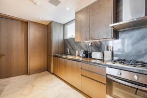 a kitchen with wooden cabinets and a stove top oven at Daniels 2BR Five Palm Breathtaking view in Dubai
