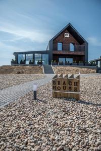 een huis op het strand met een bord ervoor bij NGlamping in Chełmża