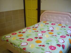 Una cama rosa con flores en una habitación en Greenleaf Angsana Homestay, en Jerantut