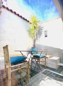 une terrasse avec une table, des chaises et un palmier dans l'établissement LA SUITE VALBONNE, à Valbonne