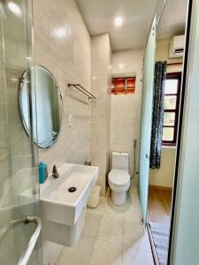 a bathroom with a sink and a toilet and a mirror at Haven Vietnam in Quy Nhon