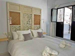 białe łóżko z dwoma parami kapci w obiekcie Apartamento La Garceta - Ole Solutions w mieście Arcos de la Frontera