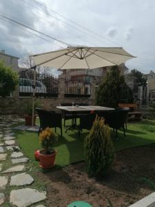 einen Tisch und Stühle mit Sonnenschirm im Hof in der Unterkunft Apartments Dona in Tschernomorez