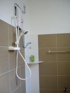 a shower with a shower head in a bathroom at Greenleaf Angsana Homestay in Jerantut