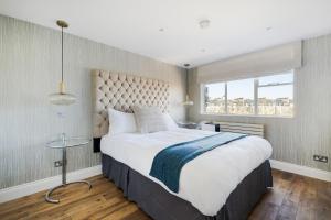 Luxury 3 Bedrooms Apartment in Central London في لندن: غرفة نوم بسرير كبير ونافذة