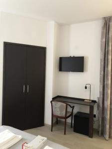 1 dormitorio con armario negro y escritorio con silla en Villa Ascosa Residence en Massascusa