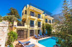 een geel huis met een zwembad ervoor bij Villa Vista Mare in Kalkan