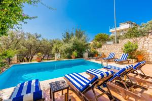 een zwembad met ligstoelen naast een villa bij Villa Vista Mare in Kalkan