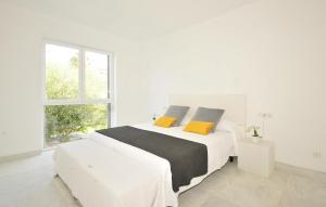 a white bedroom with a large bed with yellow pillows at Colonia Sea Holiday in Colonia Sant Jordi