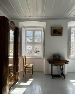a room with a table and a chair and windows at Gelhaus 1935 in Hydra