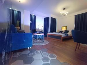 a living room with a blue couch and a bed at Square Luxury Apartments in Berovo