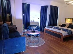 Sala de estar con cama y mesa en Square Luxury Apartments en Berovo