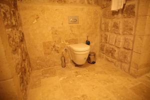 a bathroom with a toilet in a stone wall at Vita Cave Suites in Ürgüp