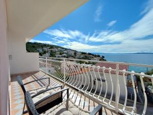 a balcony with chairs and a view of the water at Apartments Jakšić in Trogir