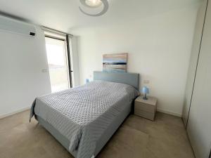 ein weißes Schlafzimmer mit einem Bett und einem Fenster in der Unterkunft Ca' Ariston in Grado