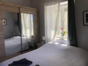 a bedroom with a mirror and a bed and a window at The Best Town View in Mýkonos City