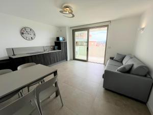 ein Wohnzimmer mit einer Couch und einer Uhr an der Wand in der Unterkunft Ca' Ariston in Grado