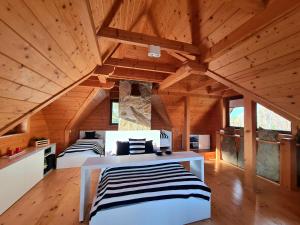 two beds in a room with wooden ceilings at Domek w Brzezowej 