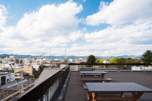 a deck with benches and a view of a city at RAKURO Kyoto by THE SHARE HOTELS in Kyoto