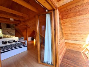 a wooden room with a large window and a bench at Domek w Brzezowej 