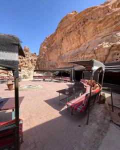 patio z łóżkiem i stołem oraz góry w obiekcie Desert stars w mieście Wadi Rum