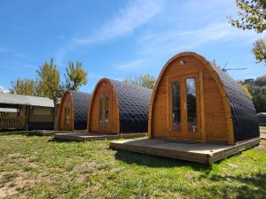 una fila de casas de madera sentadas en un campo de hierba en Camping Gran Sol, en Montferrer