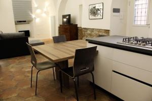 cocina con mesa de madera y algunas sillas en Casa Vacanze Le Volte Tuscania, en Tuscania