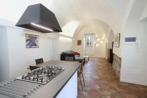 a kitchen with a stove top oven next to a living room at Casa Vacanze Le Volte Tuscania in Tuscania