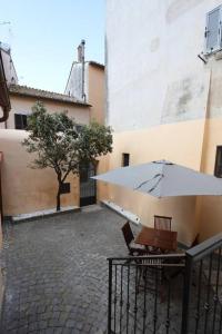 a table with an umbrella next to a building at Casa Vacanze Le Volte Tuscania in Tuscania