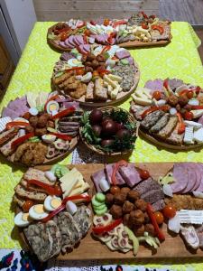una tabella piena di diversi tipi di alimenti su piatti di Casa Utan a Văleni