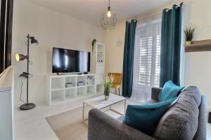 a living room with a couch and a tv at P&R1, one bedroom, city center Geneva in Geneva