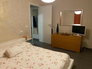 um quarto com uma cama e uma televisão numa cómoda em Zia Sara em Pietrasanta