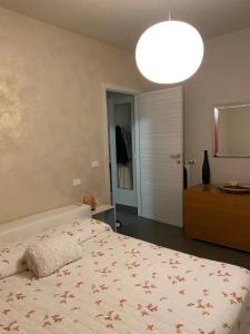 ein Schlafzimmer mit einem Bett und einem großen Licht in der Unterkunft Zia Sara in Pietrasanta