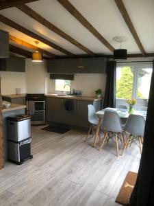 a kitchen and dining room with a table and chairs at 8F Lakeside Lodge Caer Beris Builth Wells in Builth Wells
