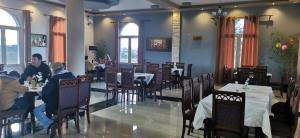 ein Speisesaal mit Menschen, die an Tischen in einem Restaurant sitzen in der Unterkunft Hotel Culaj in Koplik