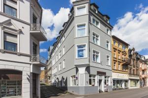 un bâtiment gris sur le côté d'une rue dans l'établissement Hotel Trabener Hof, à Traben-Trarbach