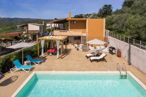 een zwembad met stoelen en een huis bij Sofias Dreamy Retreat in Katokhórion