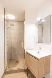 een badkamer met een wastafel en een douche bij Morphée - Résidence Hestia in Saint-Étienne